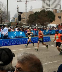 Runners sprinting past crowd during city marathon