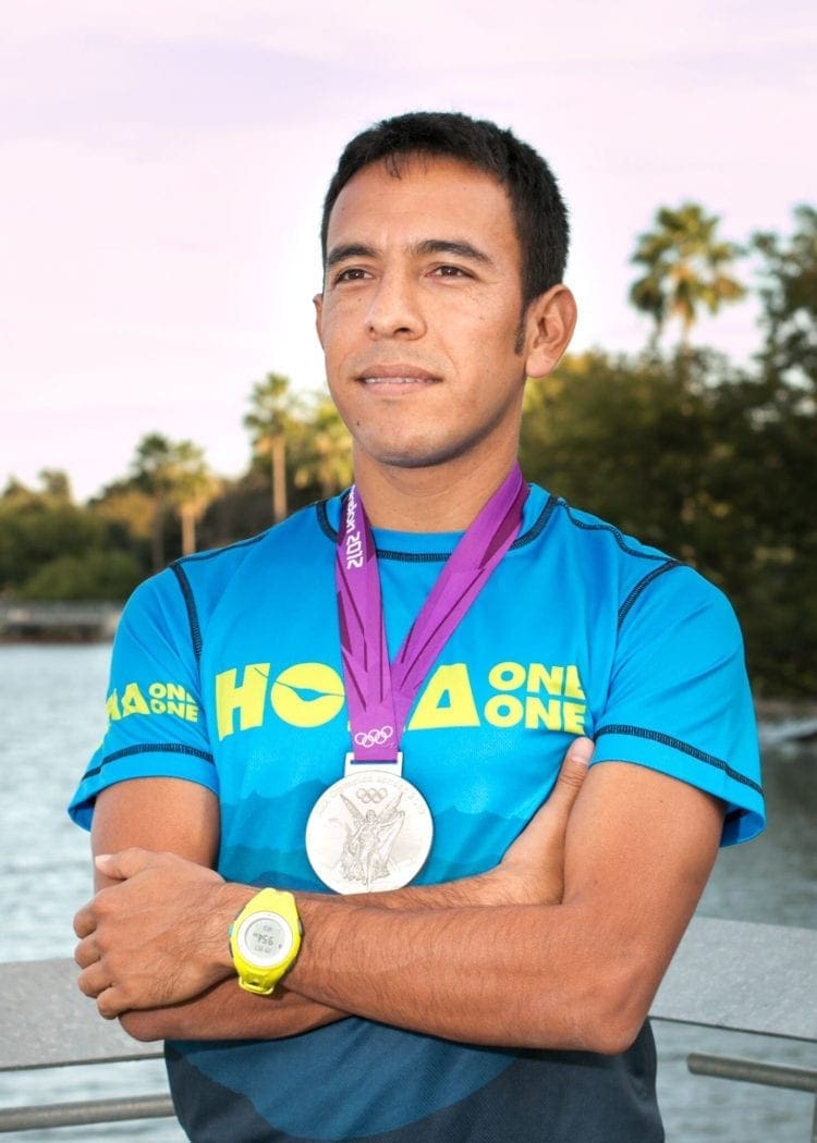 Athlete with silver medal near waterfront