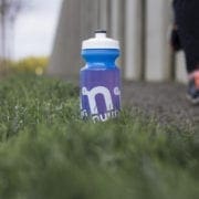 Blue water bottle on grass beside runner
