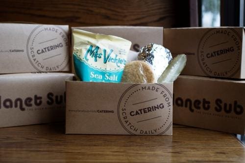 Catering box with sandwich, chips, and pickle Catering box with sandwich, chips, and pickle