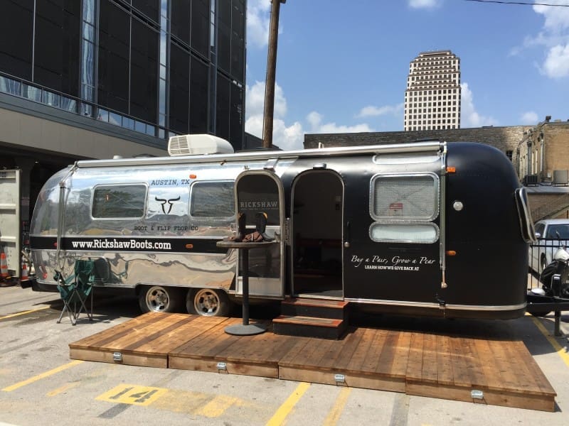 Polished silver Airstream trailer on wooden platform Polished silver Airstream trailer on wooden platform
