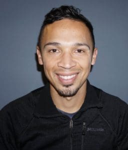 Smiling man in black zip-up jacket