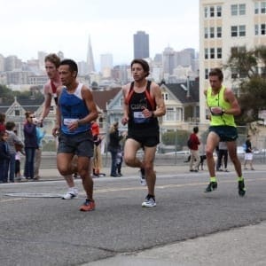 Four runners racing past urban skyline