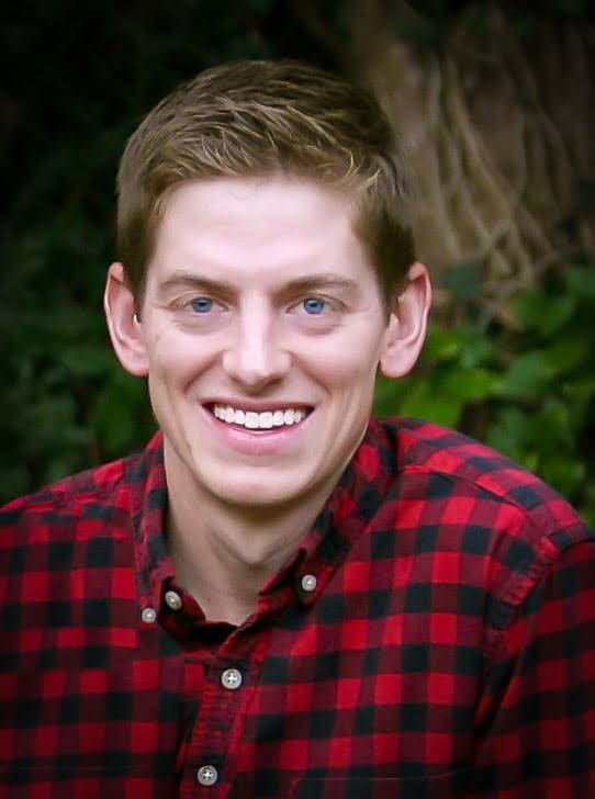 Smiling young man in red plaid shirt Smiling young man in red plaid shirt