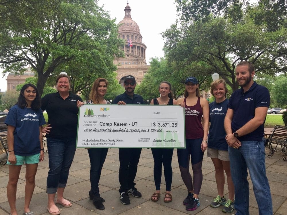 Group holding oversized donation check near capitol
