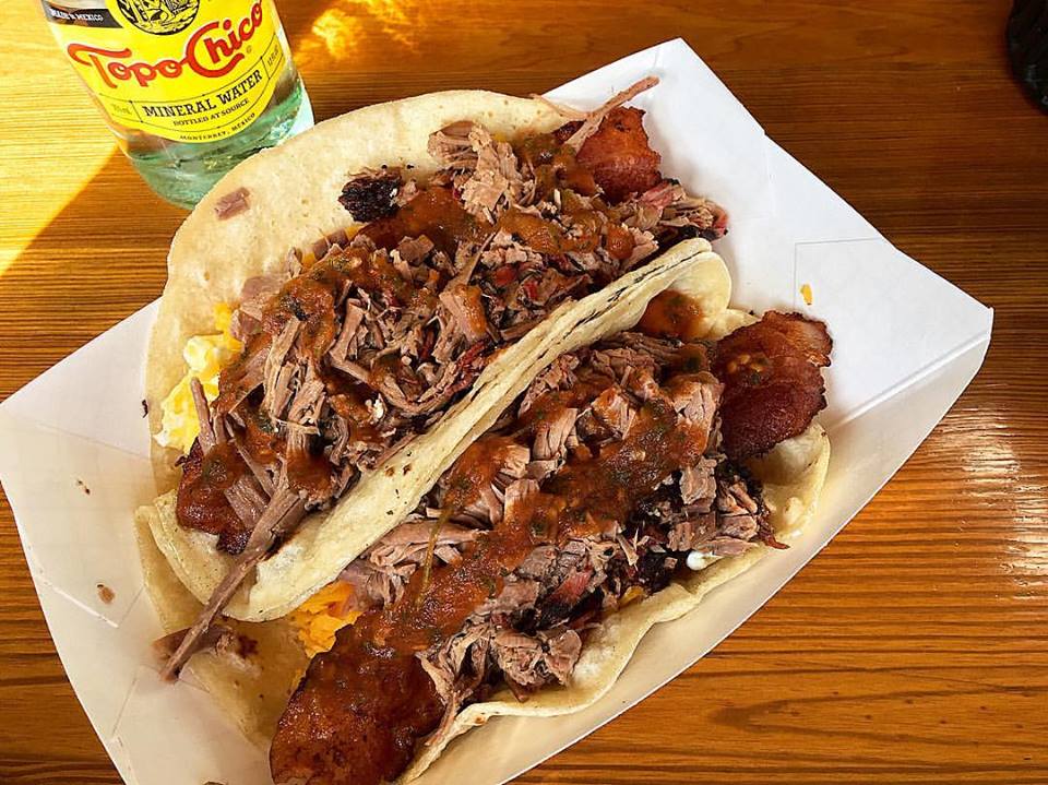 Tacos topped with shredded meat and sausages