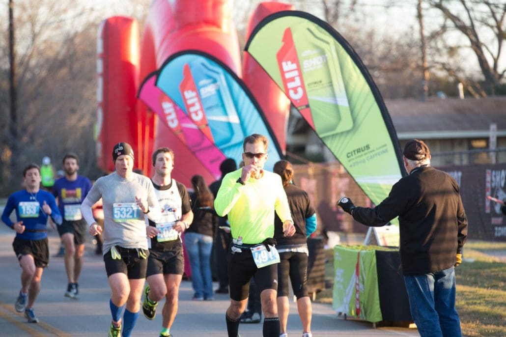 Runners passing CLIF banners during outdoor race