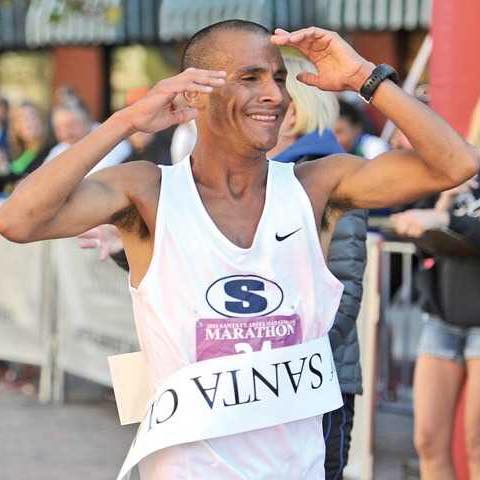 Smiling marathon runner celebrating at finish line Smiling marathon runner celebrating at finish line