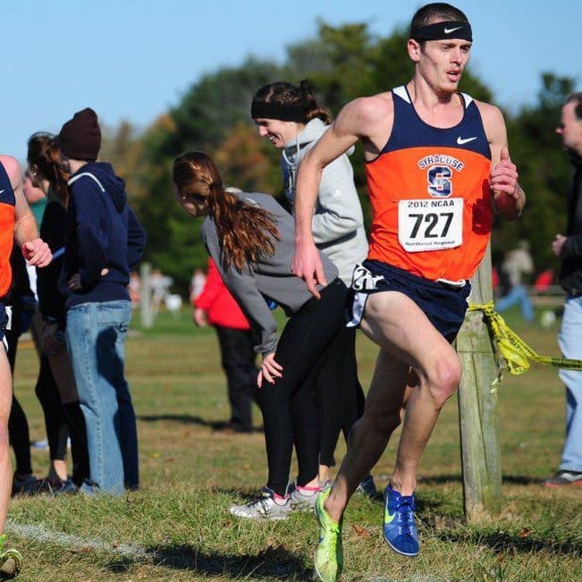 Cross-country runner in orange singlet mid-stride Cross-country runner in orange singlet mid-stride