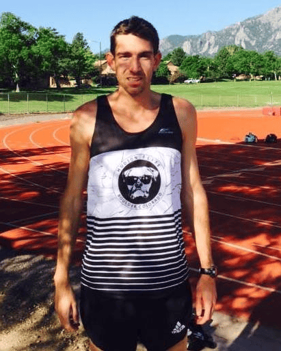 Runner standing on outdoor track near mountains Runner standing on outdoor track near mountains