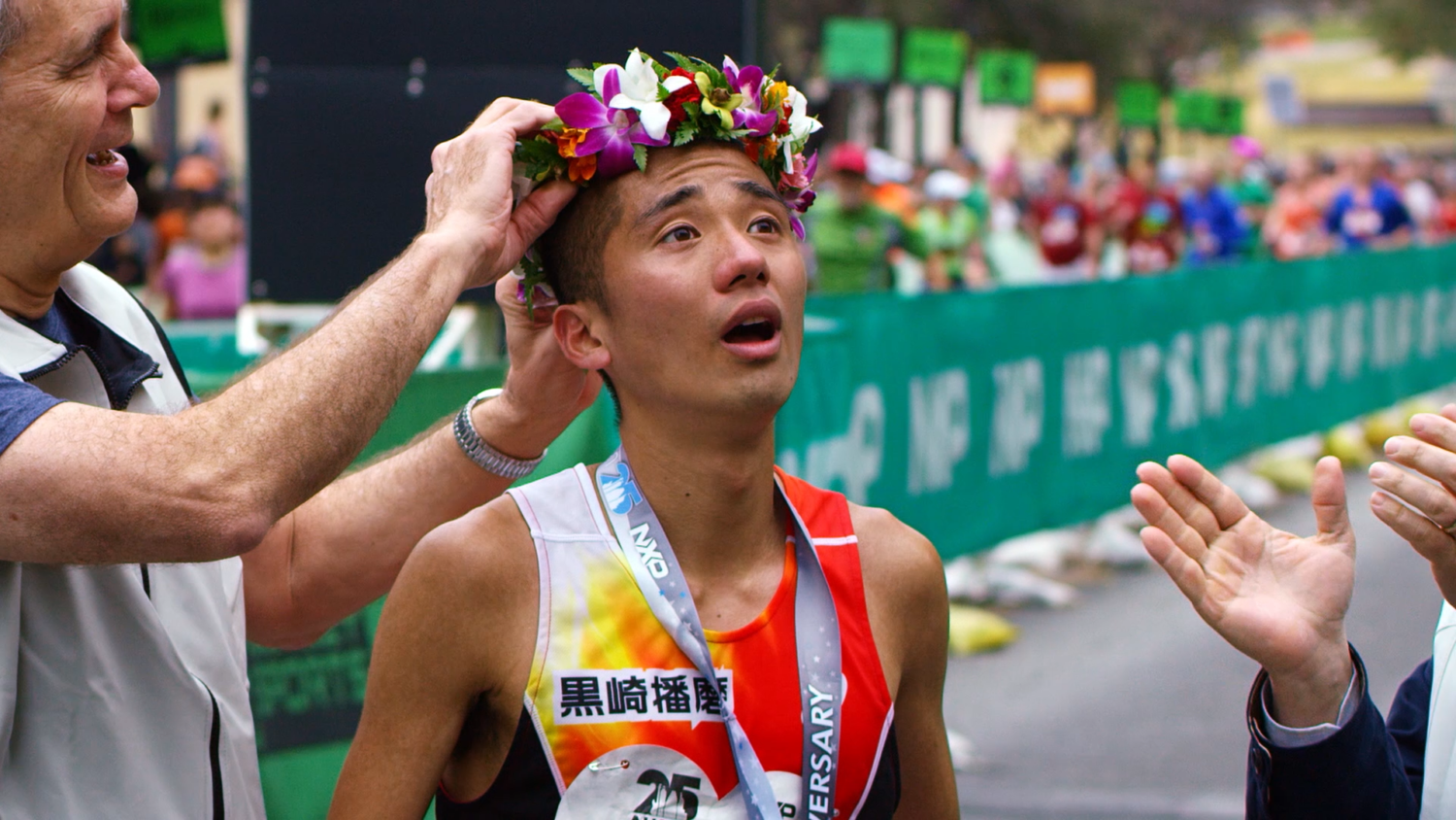 Marathon runner crowned with flower wreath at finish Marathon runner crowned with flower wreath at finish