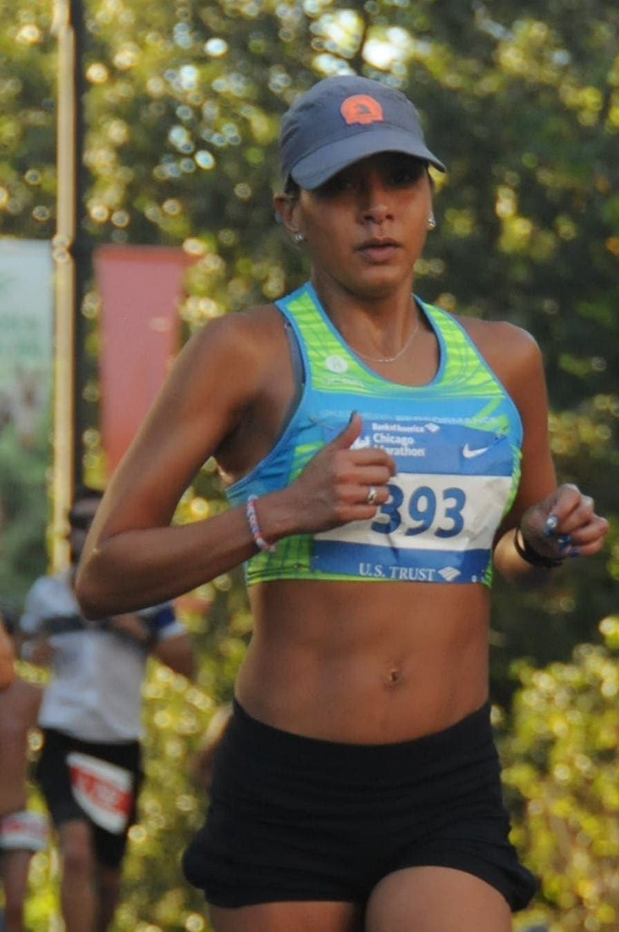 Woman running in blue sports top and cap Woman running in blue sports top and cap