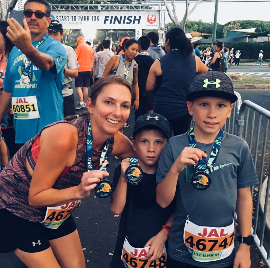 Smiling runners holding medals at finish line