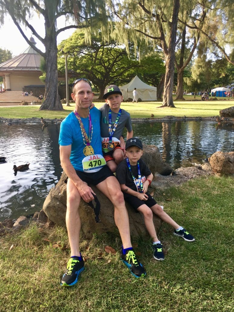 Man and two boys with race medals