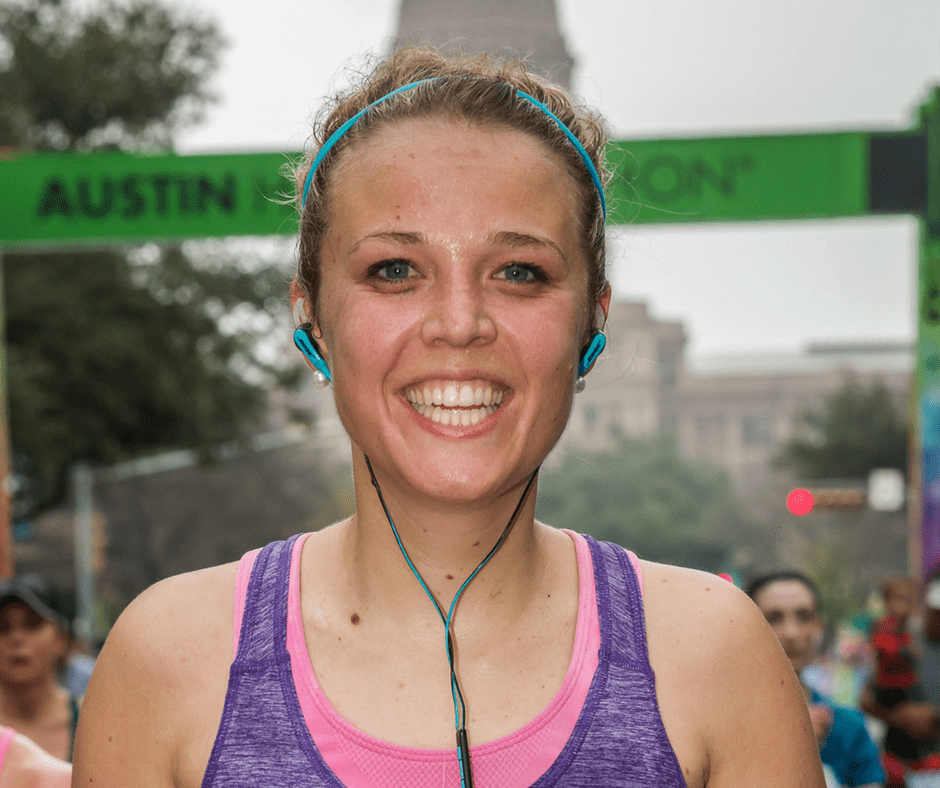 Smiling runner with teal earphones at Austin finish Smiling runner with teal earphones at Austin finish