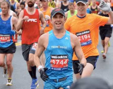 Smiling runner in blue singlet at marathon