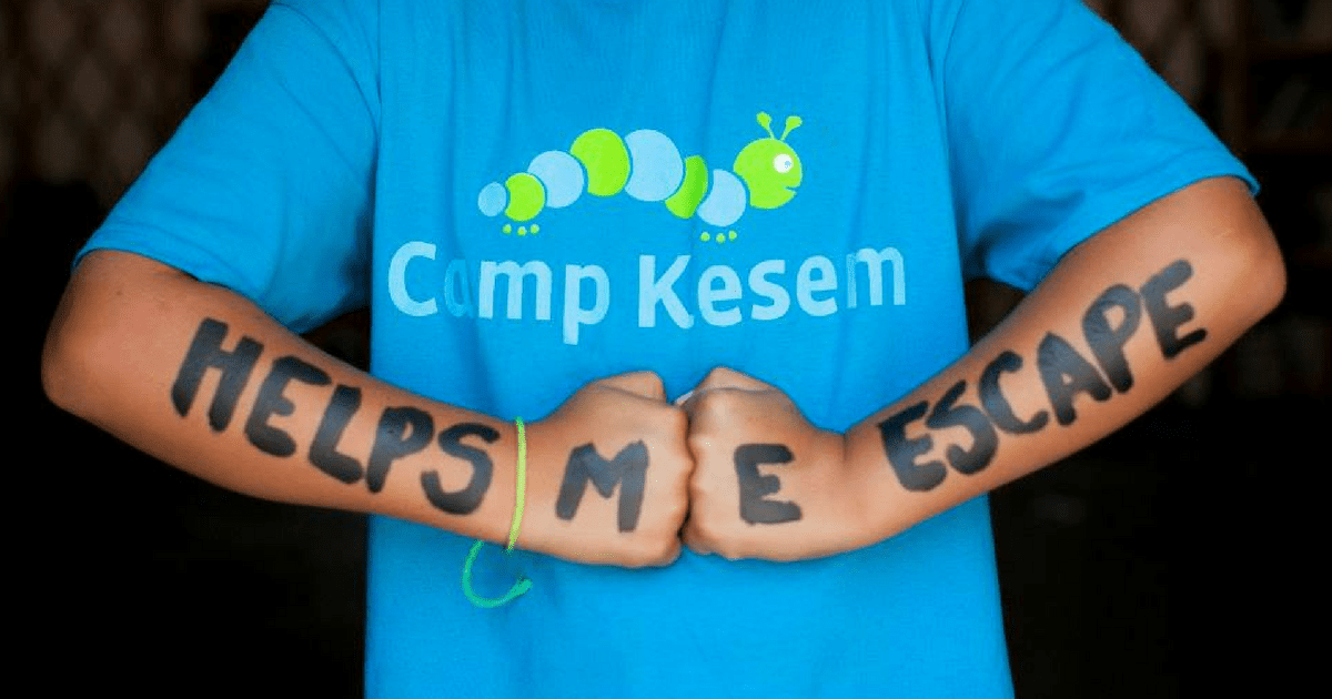 Person wearing Camp Kesem shirt, "Helps Me Escape