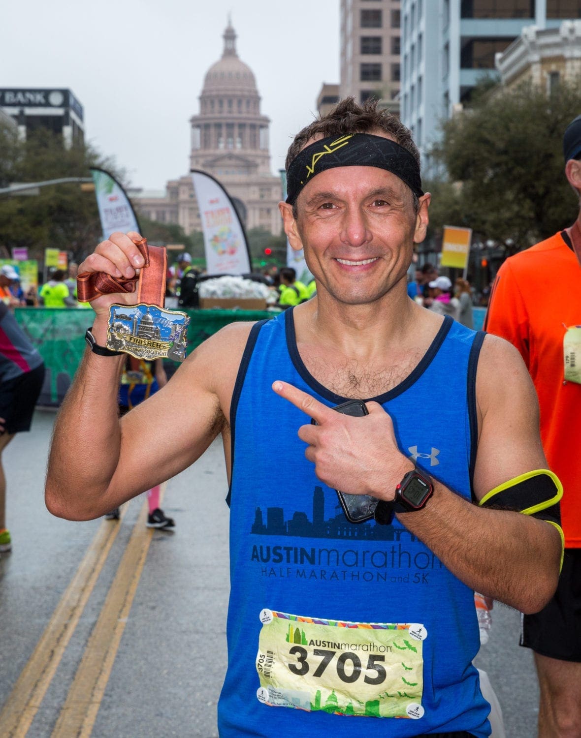 Smiling runner holding medal at Austin Marathon