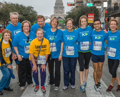 Smiling charity running team in blue shirts