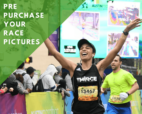 Smiling female runner raising arms at finish