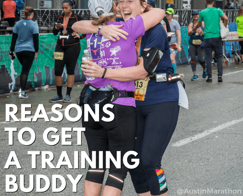 Two runners hugging at marathon finish line