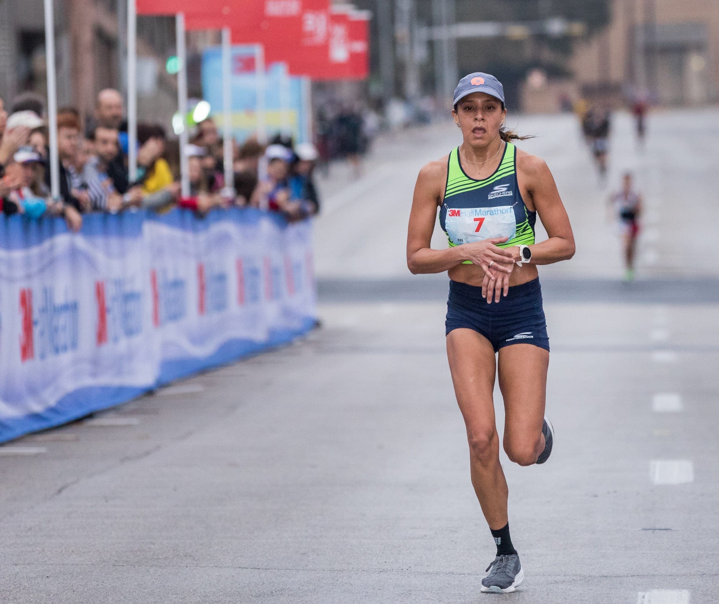 Female runner checking watch during road race
