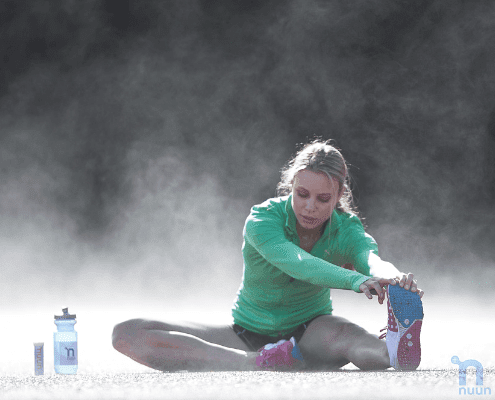 Woman stretching outdoors on misty morning