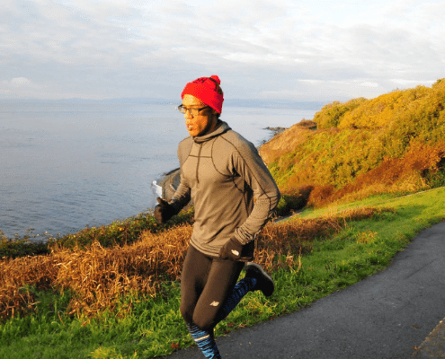 Runner in red beanie on coastal trail Runner in red beanie on coastal trail