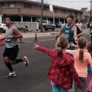 Children pointing at runners during neighborhood race