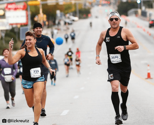 Smiling runners racing on city street