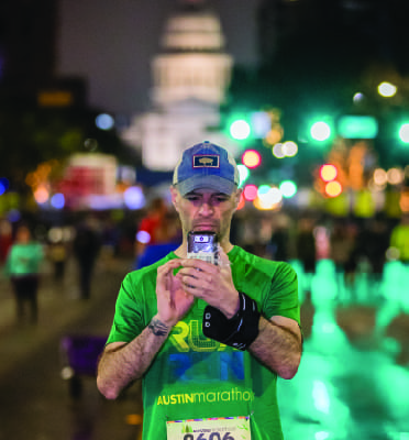 Runner taking phone photo during Austin Marathon