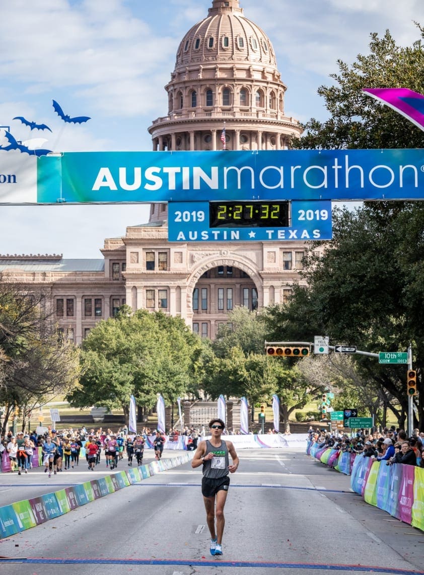 Runner approaching Austin Marathon finish with Capitol