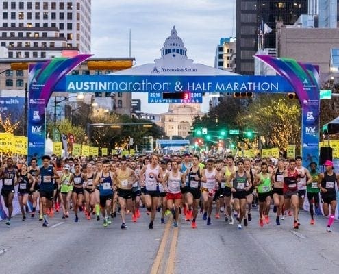 Runners starting Austin Marathon under downtown banner
