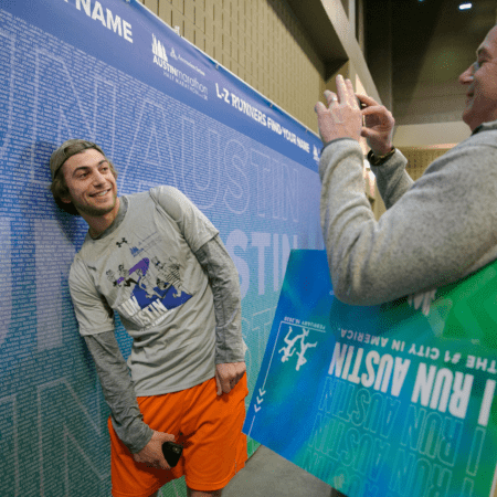 Runner posing for photo beside name wall Runner posing for photo beside name wall