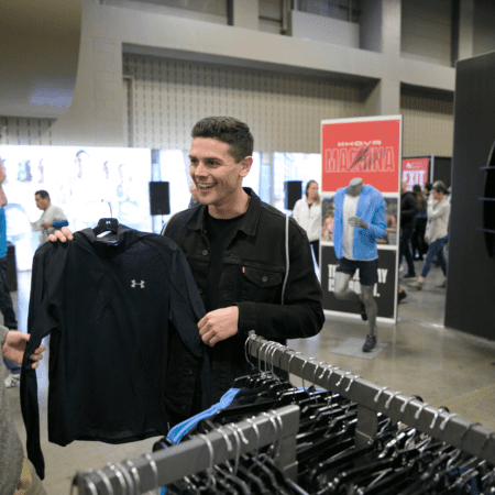 Smiling man holding black Under Armour shirt