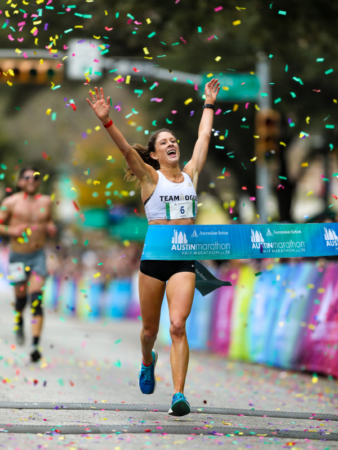 Marathon runner crossing finish line amid confetti