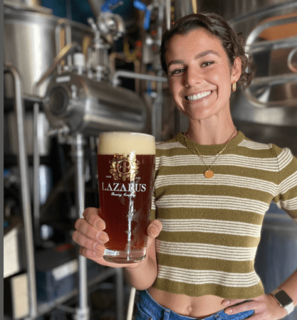 Smiling woman holding Lazarus beer glass