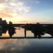 Sunset over river with bridge and skyline