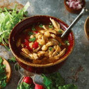 Bowl of shrimp stew garnished with herbs