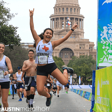 Austin Marathon runner jumping near Texas Capitol