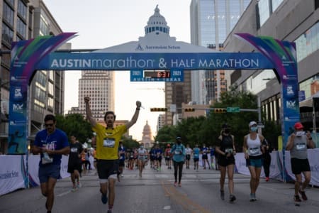 Runners crossing Austin Marathon finish line