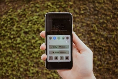 Hand holding smartphone displaying control center