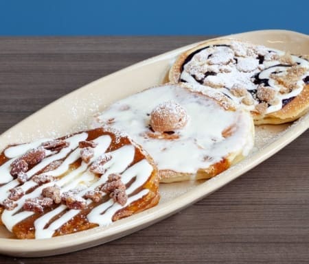 Three gourmet pancakes with assorted sweet toppings