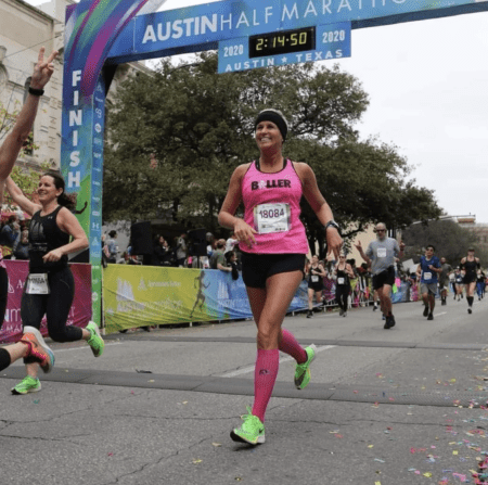 Smiling runner in pink at finish line