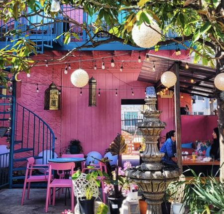 Vibrant pink outdoor cafe patio with fountain