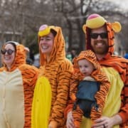 Smiling family in matching tiger onesies
