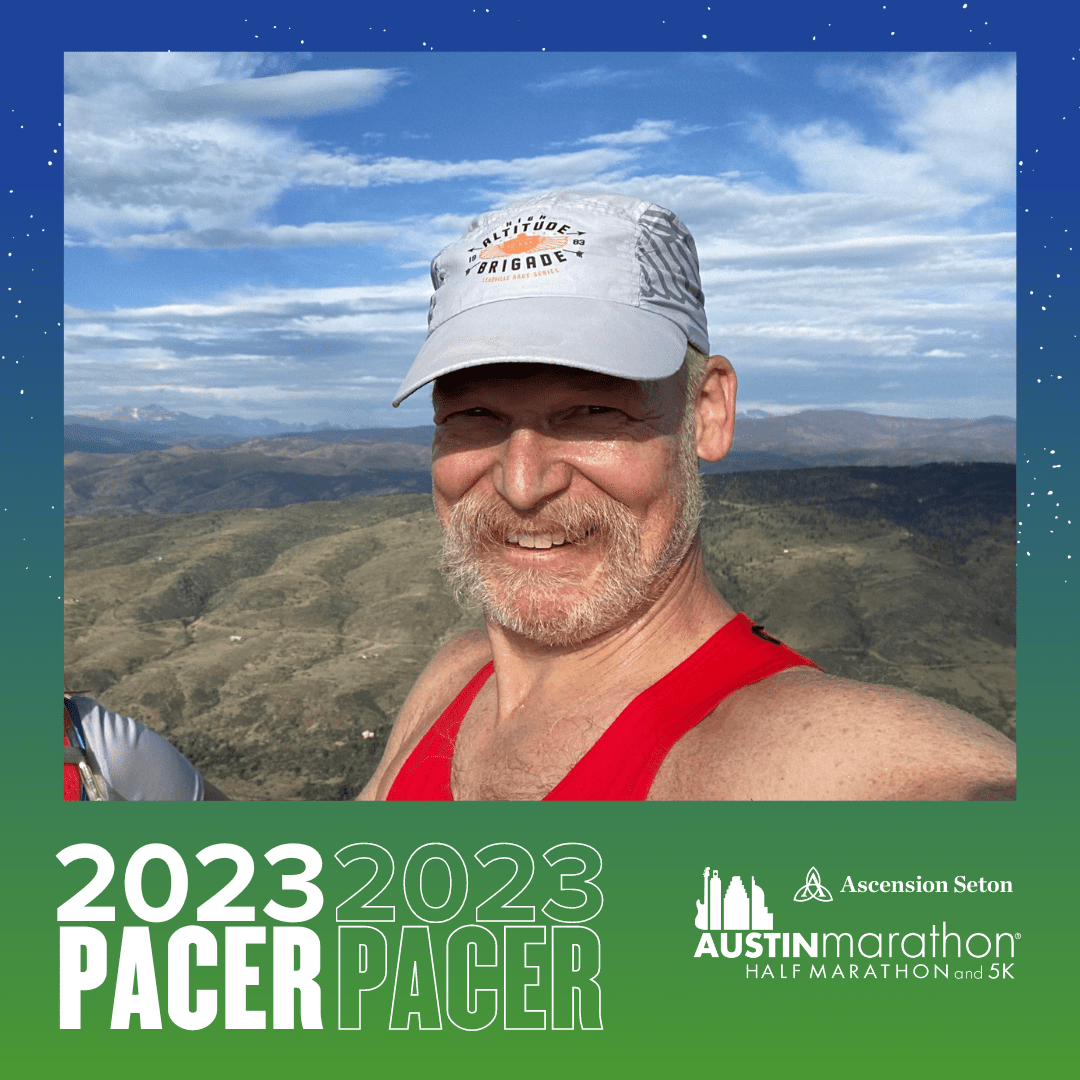 Smiling runner in cap with mountain backdrop Smiling runner in cap with mountain backdrop