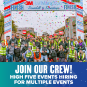 Event crew posing under marathon finish line