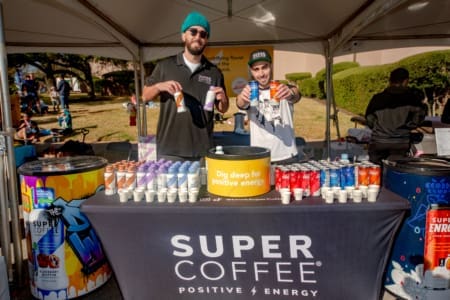 Two men at Super Coffee booth offering drinks