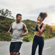 Two smiling runners on a winding road